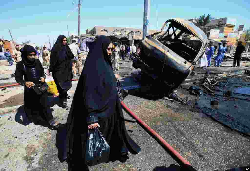 People inspect the site of a car bomb explosion in Basra, southeast of Baghdad, July 29, 2013.