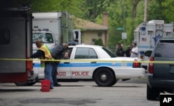 FILE - Police cordon off an area where a possible murder suspect has fired shots at officers surrounding a home where he is barricaded in Chicago, May 12, 2016.