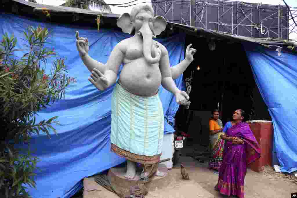 در حاشیه یک فستیوال مذهبی در حیدرآباد هند، این زن به مجسمه فیل دست دار مقابل معبدی نگاه می کند.&nbsp;