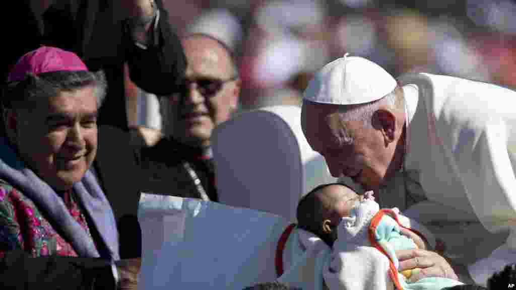 Le pape François donne un baiser à un bébé lors de sa visite, 15 février 2016.