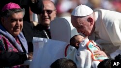 Pope Francis kisses a baby in San Cristobal de las Casas, Mexico, Feb. 15, 2016.
