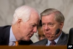 Senate Majority Whip John Cornyn, R-Texas., left, speaks with Sen. Lindsey Graham, R-S.C., right, during a Senate Judiciary Committee hearing on Capitol Hill in Washington, Oct. 3, 2017, on the Trump administration's decision to end Deferred Action for Childhood Arrivals.