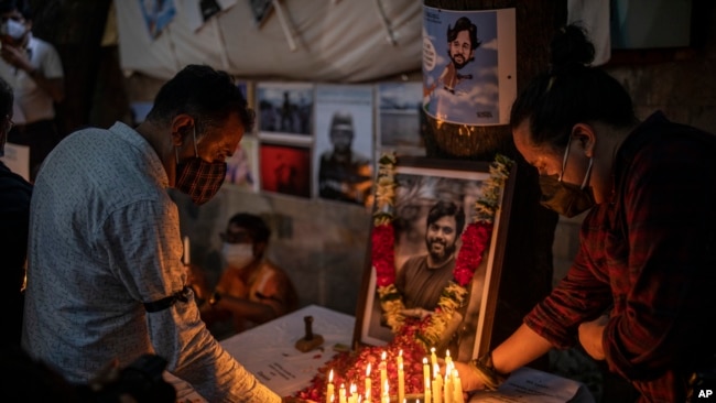 Journalists light candles and pay tribute to Reuters photographer Danish Siddiqui in New Delhi, India, Saturday, July 17, 2021.