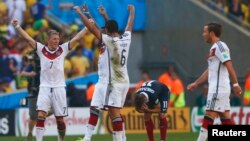 German soccer players celebrate win as France's Antoine Griezmann reacts after the final whistle is blown at 2014 World Cup quarter-finals, Maracana stadium, Rio de Janeiro, July 4, 2014.