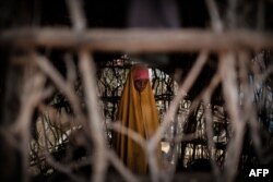 FILE - A Somali refugee girl stands in a makeshift shelter at Dadaab refugee complex, in the north-east of Kenya, on April 16, 2018.