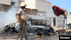 Un soldat se tient sur le lieu d’un attentat à la voiture piégée qui visait le chef de la sécurité de la ville portuaire d'Aden pour la deuxième fois en une semaine, à Aden, Yémen, 1er mai 2016.