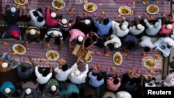 Ilustrasi. Muslim membagikan makanan saat mereka menunggu untuk berbuka puasa di luar masjid selama bulan suci Ramadhan, di Manama, Bahrain. (Foto: Reuters/Hamad I Mohammed)