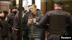 A still image taken from video footage shows Russian opposition leader Alexei Navalny in handcuffs.