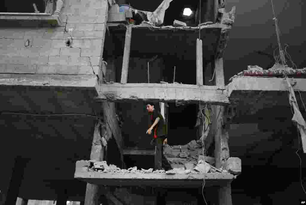 A Palestinian man looks at the damage to a house following an overnight Israeli missile strike in Gaza City, July 15, 2014.