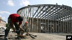 Workers build a monument around a building at School Number One in the North Ossetian town of Beslan August 18, 2011 (file photo)
