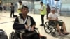 Cambodian opposition​ CNRP lawmakers Nhay Chamroeun (left) and Kong Saphea (right) are seen arriving in wheelchairs at a Bangkok airport on Tuesday, October 27, 2015, after being beaten by protesters in Phnom Penh, Cambodia. (Photo courtesy of Nhay Chamroeun) 