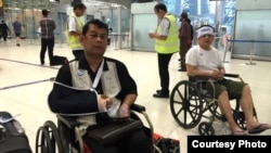 Cambodian opposition​ CNRP lawmakers Nhay Chamroeun (left) and Kong Saphea (right) are seen arriving in wheelchairs at a Bangkok airport on Tuesday, October 27, 2015 after being beaten by protesters in Phnom Penh, Cambodia on Monday. (Courtesy of Nhay Chamroeun) 