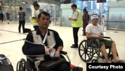Cambodian opposition​ CNRP lawmakers Nhay Chamroeun (left) and Kong Saphea (right) are seen arriving in wheelchairs at Bangkok airport on Tuesday, October 27, 2015 after being beaten by protesters in Phnom Penh, Cambodia. (Courtesy of Nhay Chamroeun)