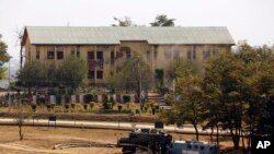 Government forces takes position behind armoured vehicles inside a paramilitary camp that was stormed by suspected rebels on the outskirts of Srinagar, Indian-controlled Kashmir, Tuesday, Oct. 3, 2017. Rebels fighting Indian rule in Kashmir stormed the pa