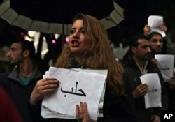 A Lebanese woman holds a paper with "Aleppo" written in Arabic as she chants slogans during a sit-in to express solidarity with residents of the Syrian city of Aleppo, in downtown Beirut, Lebanon, Dec. 13, 2016.