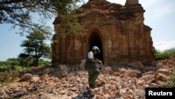 FILE - A photographer walks outside a collapsed pagoda after an earthquake in Bagan, Myanmar, Aug. 25, 2016. 