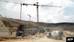 FILE - Workers and equipment are seen at a construction site at the Israeli settlement of Givat Zeev near the West Bank city of Ramallah, April 14, 2016. 