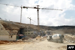 FILE - Workers and bulldozers are seen at a construction site in the Israeli settlement of Givat Zeev near the West Bank city of Ramallah, April 14, 2016.