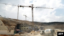 ພວກຄົນງານ ແລະ ລົດດຸດ ກຳລັງດຳເນີນງານ ຢູ່ສະຖານທີ່ກໍ່ສ້າງ ໃນພີ້ນທີ່ຕັ້ງຖິ່ນຖານໃໝ່ຂອງເມືອງ Givat Zeev ຕັ້ງຢູ່ໃກ້ກັບເມືອງ Ramallah ຂອງຝັ່ງ​ຕາ​ເວັນ​ຕົກ​ຂອງ​ແມ່ນ້ຳຈໍ​ແດັນ ຫຼື West Bank, ວັນທີ 14 ເມສາ 2016.
