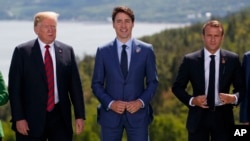 Le président Donald Trump, le premier ministre canadien Justin Trudeau et le président français Emmanuel Macron au moment de la photo de famille lors du Sommet du G-7, le vendredi 8 juin 2018, à Charlevoix, au Canada. (AP Photo / Evan Vucci)