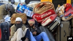 Egyptians sit next to their belongings as they wait for transportation near the Libyan and Tunisian border crossing of Ras Jdir after fleeing unrest in Libya, February 28, 2011