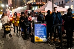 Patients wait to receive a COVID-19 vaccine booster shot at a mobile vaccination station on 59th Street below Central Park, in New York, Dec. 2, 2021.