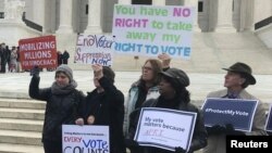 Activists rally outside the U.S. Supreme Court ahead of arguments in a key voting rights case involving a challenge to Ohio's policy of purging infrequent voters from voter registration rolls, in Washington, Jan. 10, 2018. 