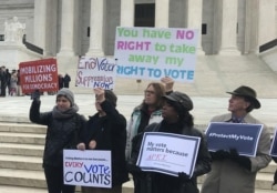 FILE - Activists rally outside the U.S. Supreme Court ahead of arguments in a key voting rights case involving a challenge to Ohio's policy of purging infrequent voters from voter registration rolls, in Washington, Jan. 10, 2018.