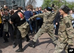 Fighters of National Liberation movement clash with protesters during clashes at a demonstration against President Vladimir Putin in Pushkin Square in Moscow, Russia, May 5, 2018.