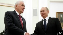 Russian President Vladimir Putin, right, and the leader of Georgia's breakaway province of South Ossetia Leonid Tibilov shake hands during their meeting in the Kremlin in Moscow, Russia, March 18, 2015.