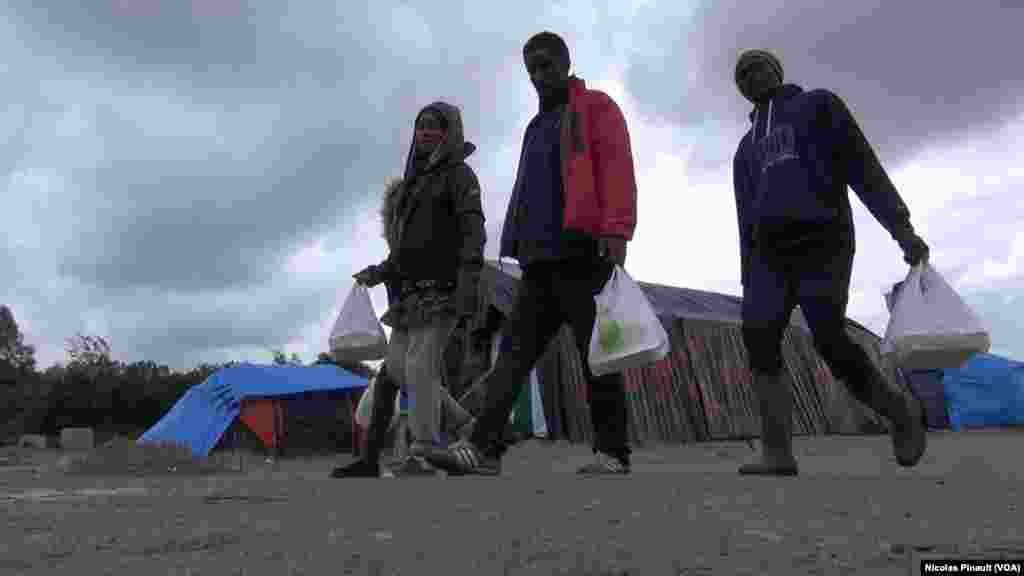 Des migrants marchent dans la &quot;jungle&quot;. Ce camp est situé aux abords de Calais dans le nord de la France, 14 octobre 2015 (Nicolas Pinault/VOA).