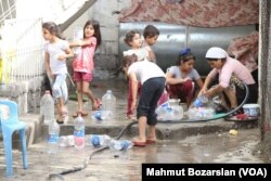 Explosions damaged water pipes, leaving trenches in the streets filled with water, Sept. 12, 2015. (Credit: Mahmut Bozarslan/VOA)