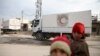 Children stand along a street as an aid convoy of Syrian Arab Red Crescent and United Nation (UN) drives through the rebel held besieged city of Douma towards the besieged town of Kafr Batna to deliver aid, on the outskirts of Damascus, Syria, Feb. 23, 2016.