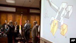Egypt's Antiquities Minister Mamdouh el-Damaty, left, speaks during a press conference as he displays images of radar scans to King Tut's burial chamber on a projector, at the Antiquities Ministry in Cairo, Egypt, March 17, 2016. El-Damaty says analysis of scans of famed King Tut's burial chamber has revealed two hidden rooms that could contain metal or organic material.