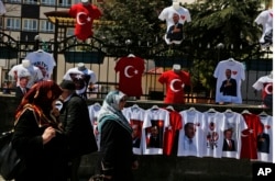 People walk past a display of T-shirts adorned with images of the Turkish flag and President Recep Tayyip Erdogan, offered for sale in his hometown city of Rize, April 4, 2017, ahead of an April 16 referendum on extending presidential powers.