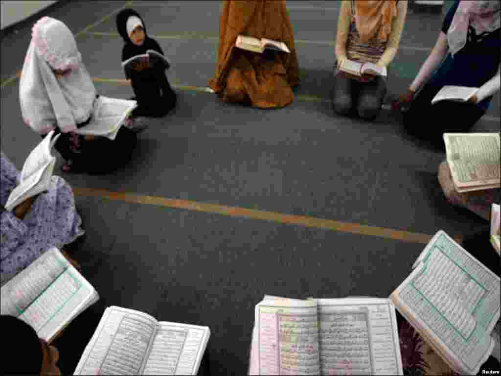 فلسطینی لڑکیاں دائرے کی شکل میں بیٹھ کر قرآن کریم کی تلاوت کررہی ہیں