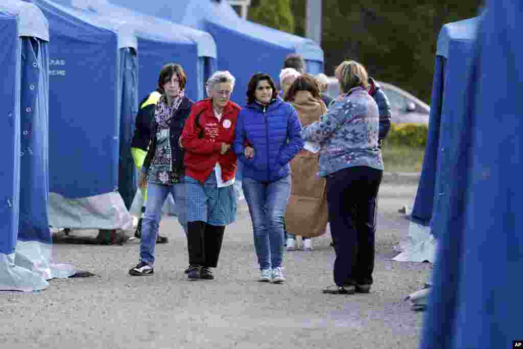 Warga berjalan di sekitar tenda kamp penampungan penyintas gempa yang kehilangan rumahnya, dekat Pescara Del Tronto, Italia (25/8). (AP/Andrew Medichini)