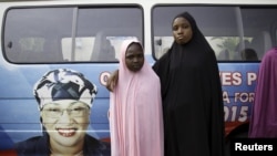 Deux jeunes filles de l'Etat de Taraba, posent fièrement devant le véhicule arborant la photo de Mme Alhassan au moment de la campagne électorale, le 10 avril 2015 (REUTERS/Afolabi Sotunde) 