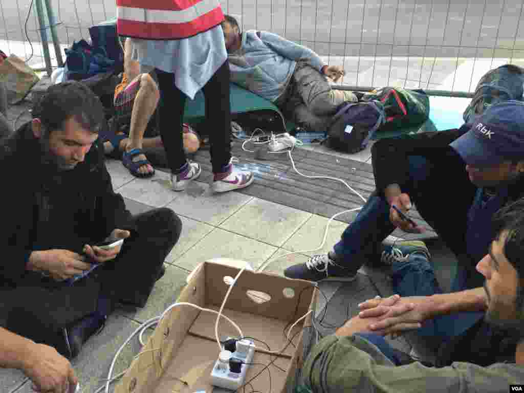 Outside a Vienna train station, aid workers provide what many refugees want most: electricity to charge mobile phones that help them navigate the perilous trip to the European Union, Sept. 15, 2015. (Heather Murdock /VOA)