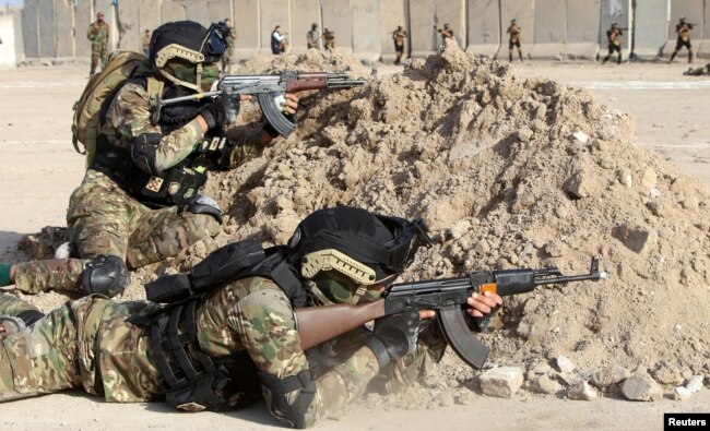 Members of Iraqi Popular Mobilization Forces demonstrate their skills during a military exercise at a graduation ceremony in Basra, Iraq Jan. 31, 2019.