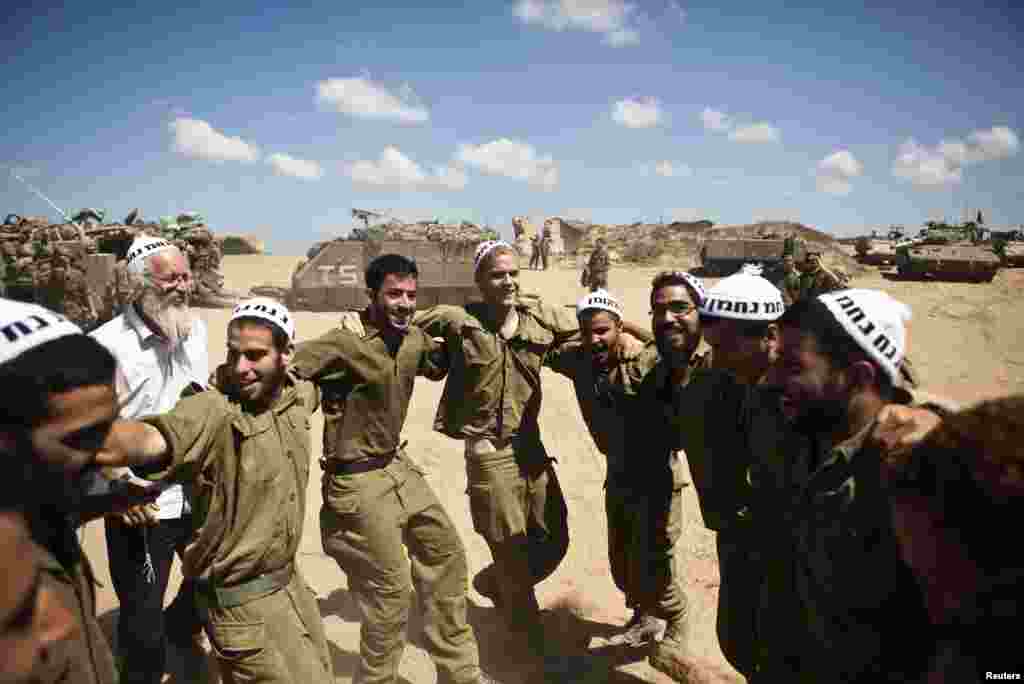 Israeli soldiers dance with members of the Breslov Hasidic sect at a military staging area outside central Gaza July 14, 2014. 