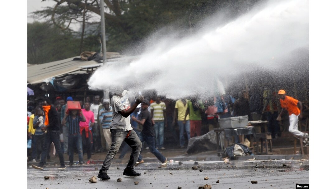 A supporter of Kenyan opposition leader Raila Odinga is sprayed with water by police in Nairobi, Nov. 17, 2017.