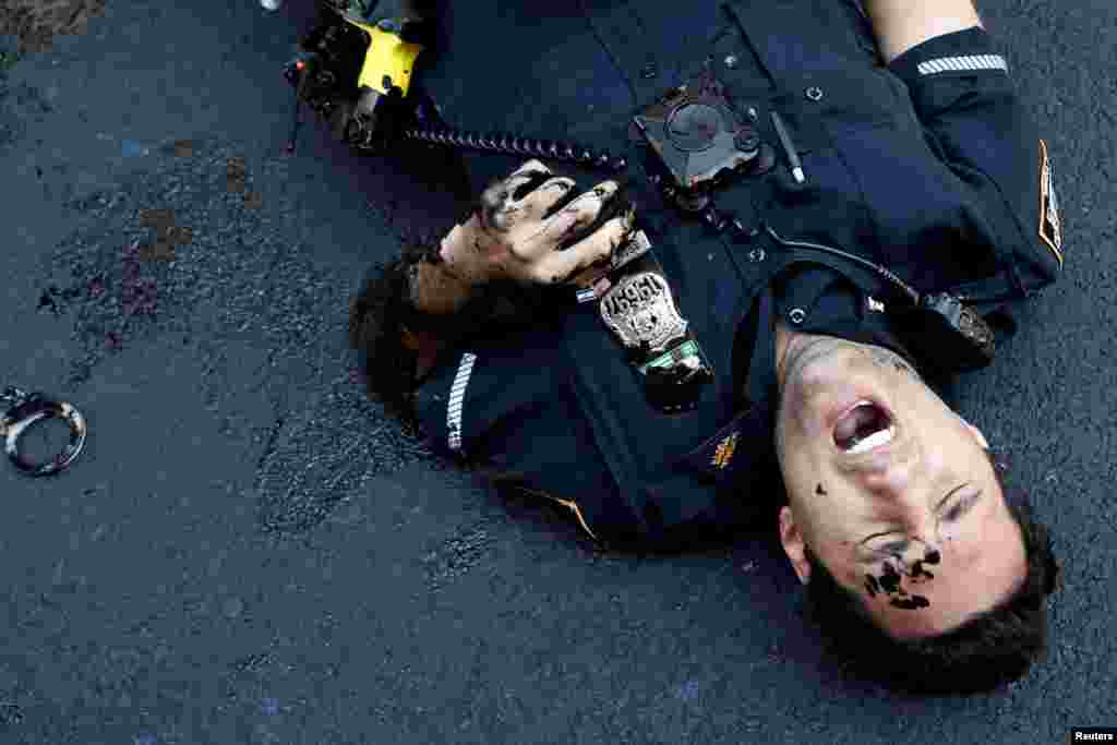 An officer from the New York Police Department is seen injured after attempting to detain a protester smearing paint on the Black Lives Matter mural outside of Trump Tower on Fifth Avenue in Manhattan, July 18, 2020.