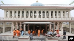 Afghan Municipality workers sweep Baqir-ul Ulom mosque after a suicide attack, in Kabul, Afghanistan, Nov. 21, 2016.