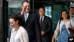 Marcelo Ebrard, Mexico's Secretary of Foreign Affairs, second from left, waves as he and members of his staff walk out of the State Department after a meeting to talk about tariffs, June 6, 2019, in Washington. 