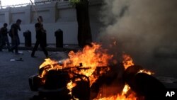穆爾西的支持者和反對者之間的衝突繼續,星期一民眾在開羅燒焚一部機車。
