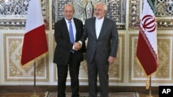 Iranian Foreign Minister Mohammad Javad Zarif, right, and his French counterpart Jean-Yves Le Drian, shake hands for journalists at the start of their meeting in Tehran, March 5, 2018. 