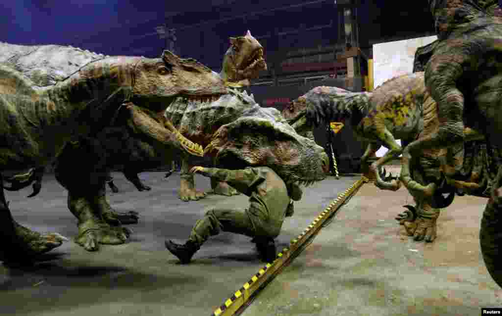 Japan&#39;s ON-ART Corp&#39;s eight-meter tall man-operated walking dinosaur robot &#39;TRX03&#39; (C) performs with other robots at the company&#39;s studio in Tokorozawa.