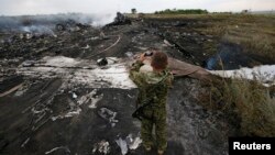 Một thành viên của phe ly khai thân Nga chụp ảnh hiện trường chiếc máy bay Boeing 777, MH17, của hãng hàng không Malaysia Airlines bị bắn hạ ở khu vực Donetsk vào ngày 17/7/2014.