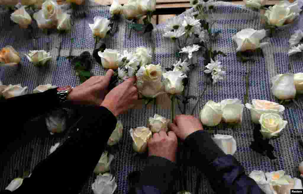 Women place roses on the agriculture building in Bogota as tribute to Colombia's President Juan Manuel Santos after he won the Nobel Peace Prize.